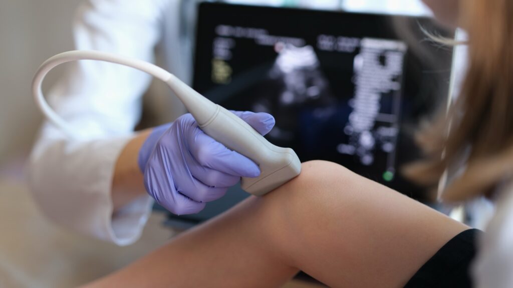 Doctor,Conducting,Ultrasound,Examination,Of,Knee,Joint,In,Child,Closeup.