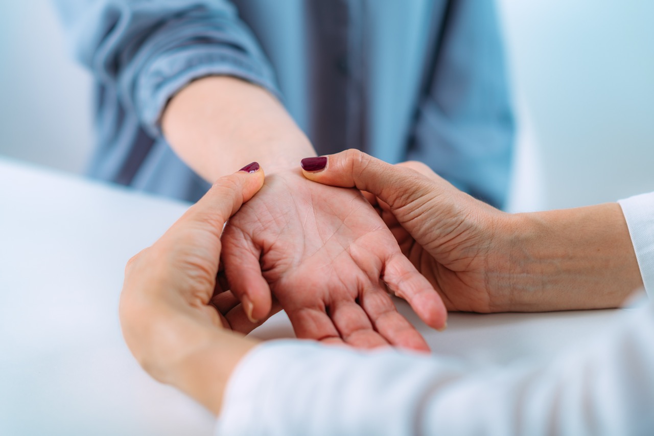 A doctor examines a patient’s hand as they discuss the carpal tunnel surgery recovery time.